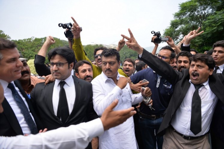 Pakistani lawyers (right) shout slogans next to ruling party leader Daniyal Aziz (left) against then prime minister Nawaz Sharif outside the Supreme Court building during a hearing on the Panama Papers case in Islamabad on July 17, 2017, after the Joint Investigation Team (JIT) presented a final report of the investigation probing allegations of money laundering against Sharif and his family. 