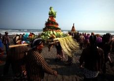 Dressed in traditional Javanese costumes, men carry cone-shaped towers of vegetables and fruits that are to be placed at sea. JP/Boy T. Harjanto