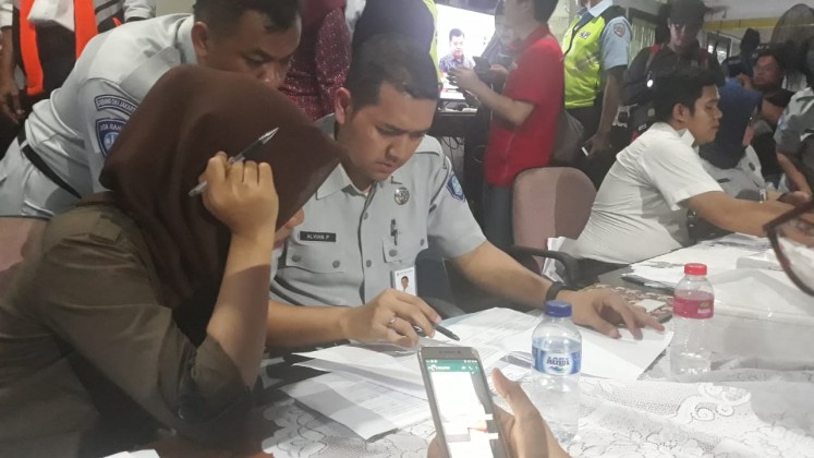 Officials from state-owned insurance company Jasa Raharja check the names listed in the manifest of Lion Air flight JT610 reported by family members in the crisis center in Halim Perdanakusuma Airport on Monday, Oct. 29.