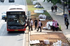 Passengers wait for a Transjakarta bus at a newly built bus stop on Jl. Sudirman, Central Jakarta.