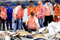 Members of the United States National Transportation Safety Board analyze on Thursday debris from Lion Air flight JT610 at Tanjung Priok Port in North Jakarta. The plane crashed into the Java Sea on Monday morning shortly after departing Soekarno-Hatta International Airport, Banten.