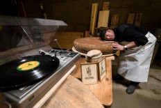 Swiss cheesemaker Beat Wampfler lays his head on a wheel of Emmental, one of the most famous cheeses in Switzerland, as it is being matured in music with small music speakers directly below, on October 19, 2018 in Berthoud.