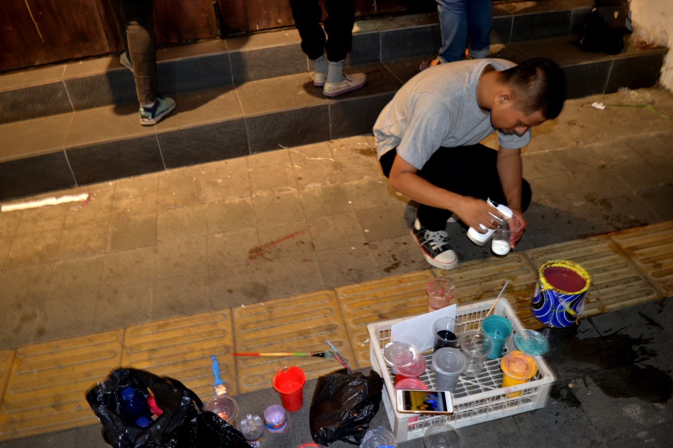 Salah seorang seniman mural sedang menggabungkan cat yang akan digunakan untuk melukis mural | Foto: