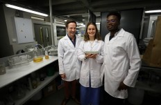 Researchers Dr Dyllon Randall, Suzanne Lambert and Vukheta Mukhari stand with a bio-brick made from urine at the University of Cape Town, in Cape Town, South Africa November 2, 2018. The odourless, grey prototype brick was grown in a mould in the lab over eight days and is the final product in a process that also produces fertilizers. 
