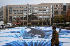 A giant banner depicting a killer whale and ice floe, is displayed near the European Union headquarters in Brussels, on Oct. 18, to call leaders to undertake action to protect the waters in the Antarctic region. 