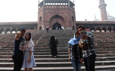 Tourists pose for photographs outside Jama Masjid amid heavy smog in the Indian capital New Delhi on Nov. 16, 2017