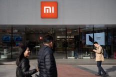 People walk past a Xiaomi shop in Beijing on November 7, 2018. 