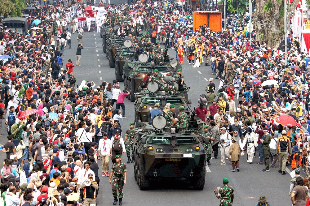 Spectators rush to photograph a convoy of Anoa armored personnel carriers taking part in the Surabaya Juang Parade in Surabaya, East Java, on Sunday.The parade was part of the celebration of National Heroes Day.