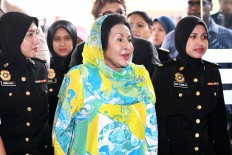 Latest blow: Rosmah Mansor (center), the wife of former Malaysian prime minister Najib Razak, is escorted by police during her arrival at court in Kuala Lumpur on Thursday, before she was charged with two counts of graft.