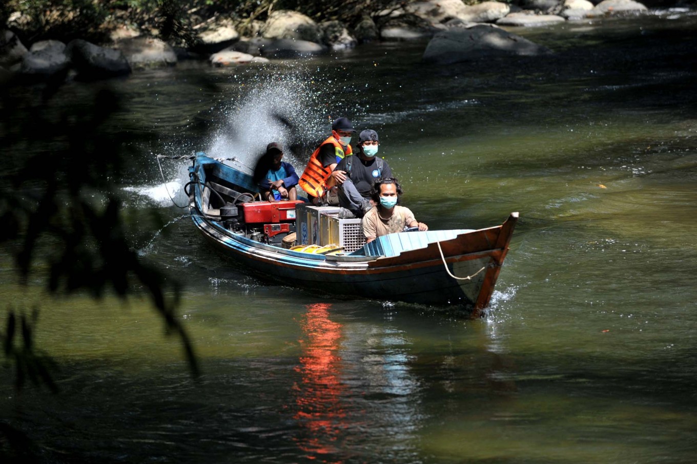 Melalui jalur darat atau air: Tim IAR mengangkut orangutan dengan perahu di Sungai Mentawai untuk masuk ke hutan yang dalam, di mana mereka akan dibebaskan | Foto: Dasril Roszandi / Jakarta Post