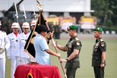 Indonesian Military (TNI) commander Air Chief Marshal Hadi Tjahjanto (left) gives a military ensign to newly-appointed Army Chief General Andika Perkasa, as witnessed by his predecessor General Mulyono during the Army command handover ceremony.