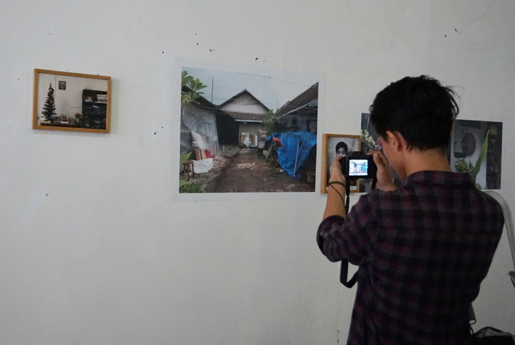 A photographer takes a photo at Ng Swan Ti's 'Rumah Masa Kecil' (Childhood House) exhibition at the launch of the #AkuSiapBersikap campaign on Nov. 27 at Budi Luhur University in Tangerang, Banten.