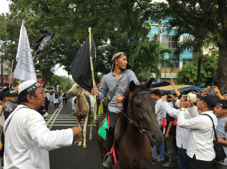 People attending the rally on Dec. 2, 2018, put on a number of performances, which included parading on horses and waving flags bearing the tawhid (oneness of God). Thousands of Muslims gathered in Medan, North Sumatra, to mark the anniversary of the 2016 anti-Ahok rally.