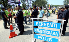 Malaysian police (in foreground) stand guard during an "Occupy Balok-Gebeng" rally against Australian miner Lynas Corporation in Kuantan, some 260 kilometers east of Kuala Lumpur, Malaysia, on June 24, 2012. 