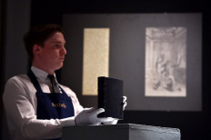 An assistant holds a copy of French writer Marcel Proust's manuscript 