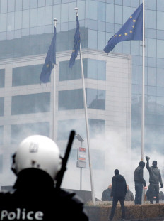 A police officer watches as far-right supporters protest the Marrakesh Migration Pact outside the European Union External Action Service building in Brussels on Sunday.