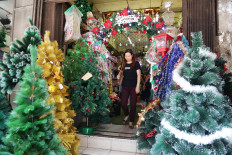 A visitor leaves a store selling Christmas decorations at Asemka Market on Wednesday in West Jakarta. Seasonal stores are seeing a surge in customers as Christmas approaches.