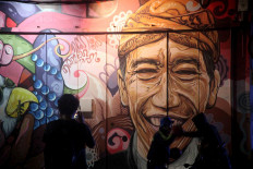 High five: Locals greet each other at a mural near Jl. Gatot Subroto in Surakarta. JP/Maksum Nur Fauzan