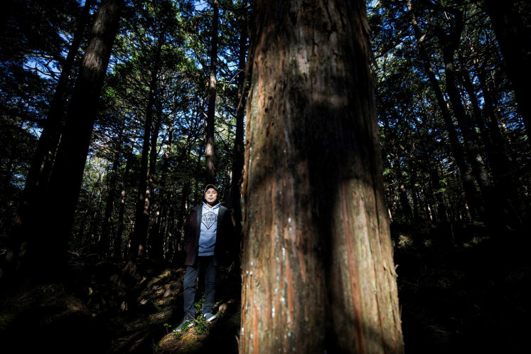 In this picture taken on November 1, 2018 Japanese musician Kyochi Watanabe poses for a photo in Aokigahara Forest, known as Suicide Forest, in Narusawa village, Yamanashi prefecture. 