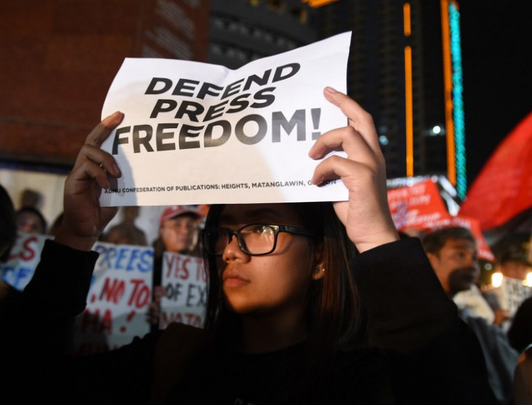 A protester in black displays a placard calling for press freedom during a protest with journalists in Manila on January 19, 2018. Philippine journalists took to the streets on January 19 in support of a news website facing state-enforced closure, accusing President Rodrigo Duterte of trampling on press freedom.
