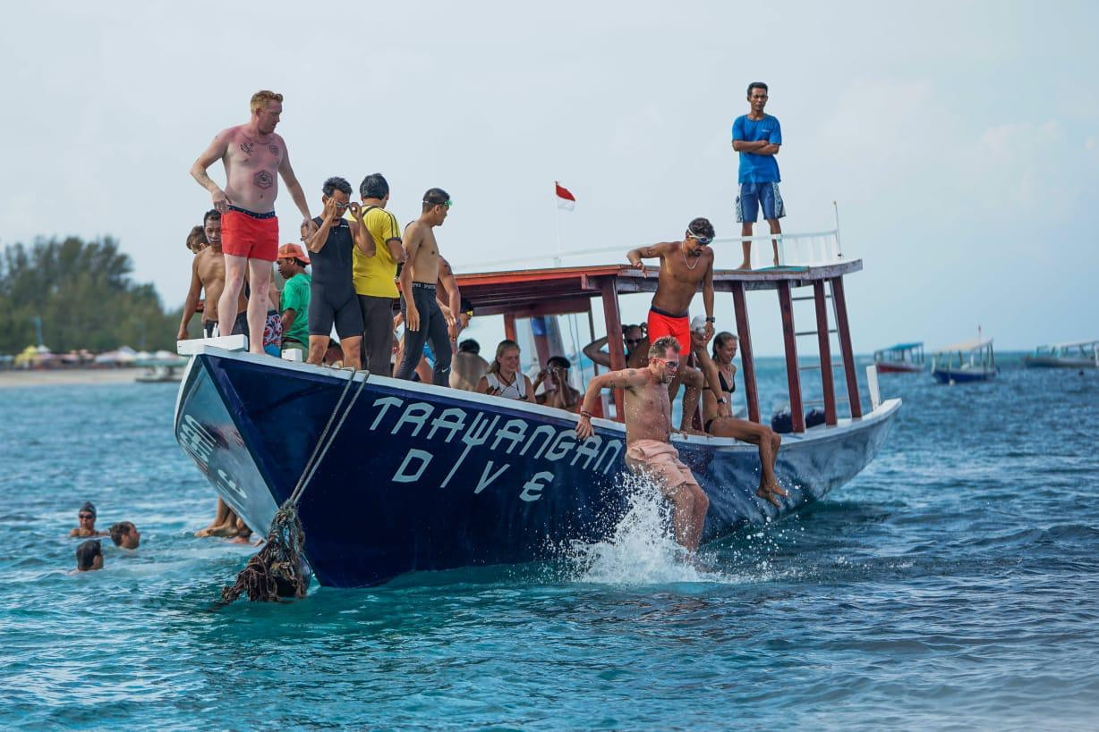 Gili Strong Triathlon participants jump into the water to start the swimming part of the race.