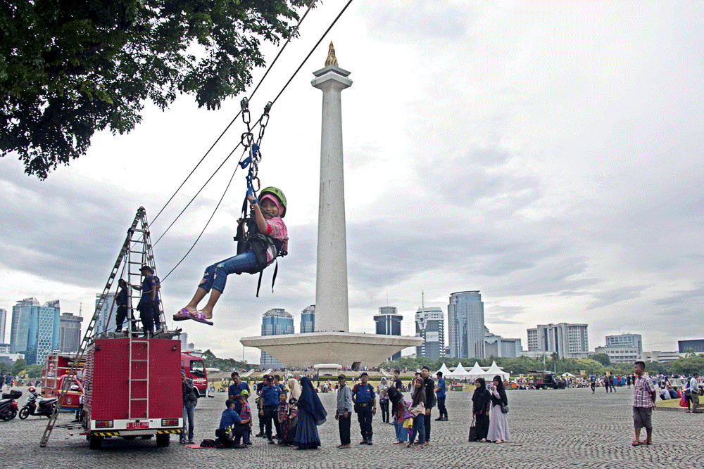 Daredevil: A young visitor rides the Flying Fox at the National Monument (Monas) complex in Central Jakarta.