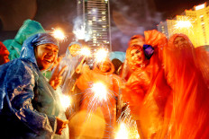 Full of cheer: Jakartans celebrate New Year’s Eve with fireworks at the Hotel Indonesia traffic circle on Monday. Rain that had been pouring since the afternoon did not stop revelers from welcoming 2019 with joy.