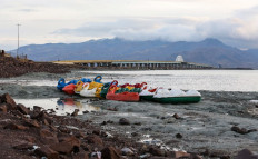 This picture taken on December 8, 2018 shows a general view of recreational boats along the shore of the salt lake of Urmia and Shahid Kalantari causeway crossing it, in the northwest of Iran which had been shrinking in one of the worst ecological disasters of the past 25 years. 