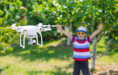 A child plays with a quadcopter drone outdoors.