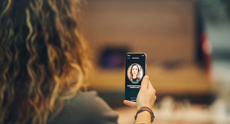 A user uses facial recognition on a smartphone in this undated photograph.
