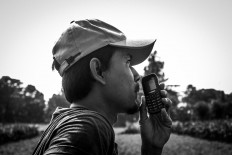 A pelingsir communicates with a “jockey” using a walkie-talkie. JP/Anggertimur Lanang Tinarbuko