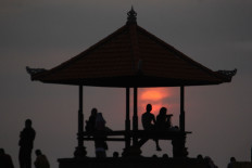 New dawn: Tourists watch the sunrise at Sanur Beach in Bali on Tuesday. JP/Zul Trio Anggono