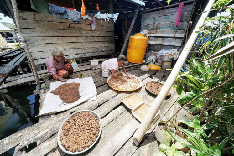 Natural light: Sowek women prepare the processed aibon flour to dry under the sunlight.
