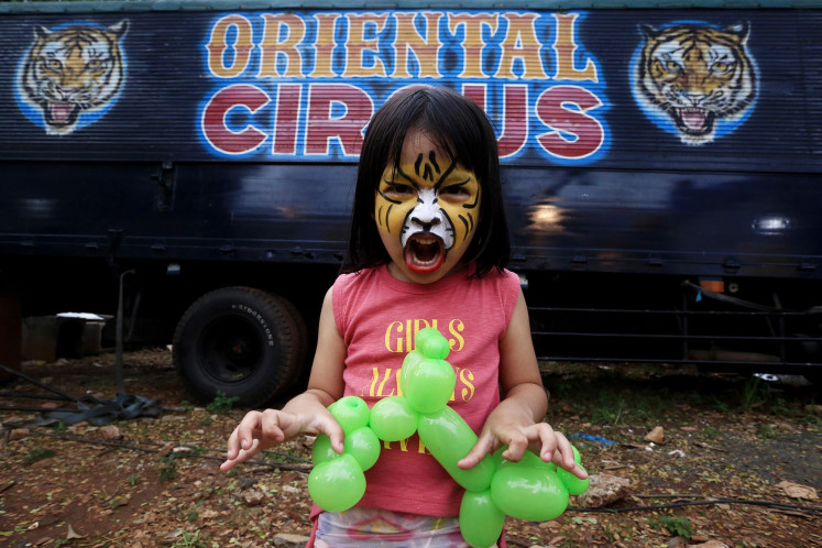 Hear me roar: A girl growls like a tiger as she waits for the opening of The Great 50 Show by the Oriental Circus Indonesia. JP/Dhoni Setiawan