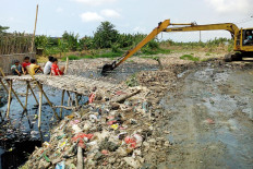 Wasteland: Local children watch as a backhoe dredges garbage from the Pisang Batu River in Pahlawan Setia village in Tarumajaya subdistrict, Bekasi regency, West Java.
