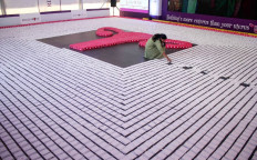 An Indian woman arranging sanitary napkins on Jan. 10, 2019 during an attempt to enter the Guinness World Record by creating the longest line of sanitary pads at the 62nd edition of 'All India Congress of Obstetrics and Gynaecology (AICOG)' in Bangalore. 