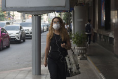A woman wears a face mask on the way to work while smog blankets Bangkok on January 14, 2019. 