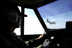 A CASA C-212-300 Aviocar aircraft belonging to Thailand’s Bureau of Royal Rainmaking and Agricultural Aviation is seen from the cockpit of another C-212-300 as both planes fly over the outskirts of Bangkok during an operation to seed clouds and reduce air pollution on Tuesday. 
