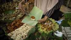 Sweet treats: A seller packs a cake on a banana leaf. Many of the cakes are made of rice flour, brown sugar, banana and shredded coconut. JP/Tarko Sudiarno