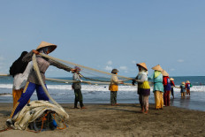 Fisherfolk pull in their fishing net from the waters off the east coast of Pangandaran. Visitors can buy the fish from the fisherfolk at a low price. JP/Arya Dipa