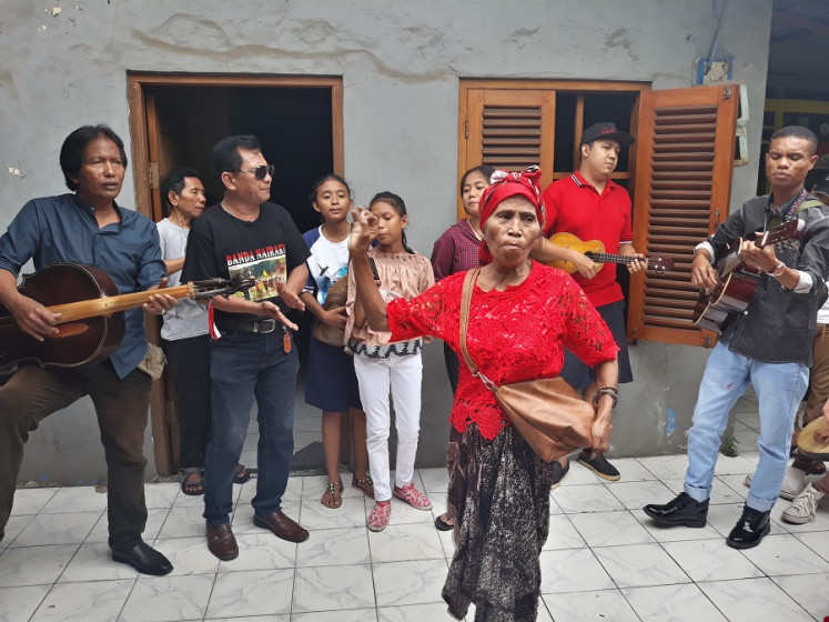 Shake it up: Erni Michiels (center) performs a song accompanied by her neighbors on guitar during Rabo-Rabo in Kampung Tugu, North Jakarta.