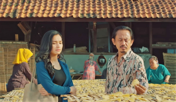 New business: Kang Mus (right), along with Kinanti (Tya Arifin), inspects his 'kecimpring' snack business.