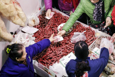 A customer purchases cured meat at a food exhibition in Shanghai, China, on Jan. 26, 2019. 

