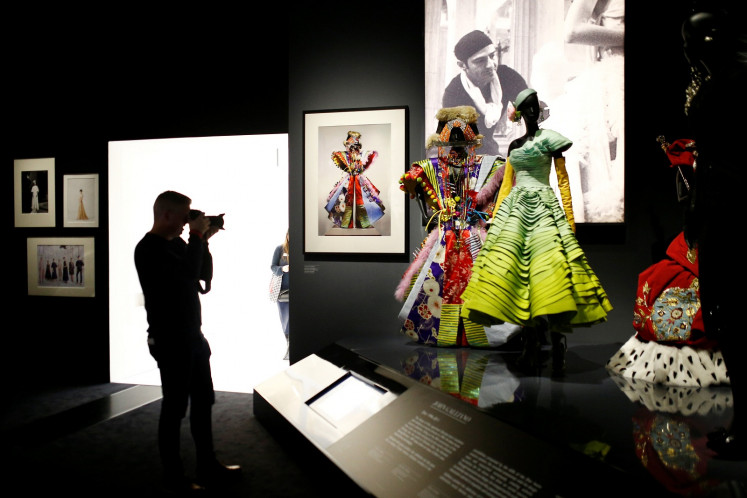 A person photographs creations during a photocall for the 'Christian Dior: Designer of Dreams' exhibition at the Victoria & Albert (V&A) Museum in London, Britain January 30, 2019. 