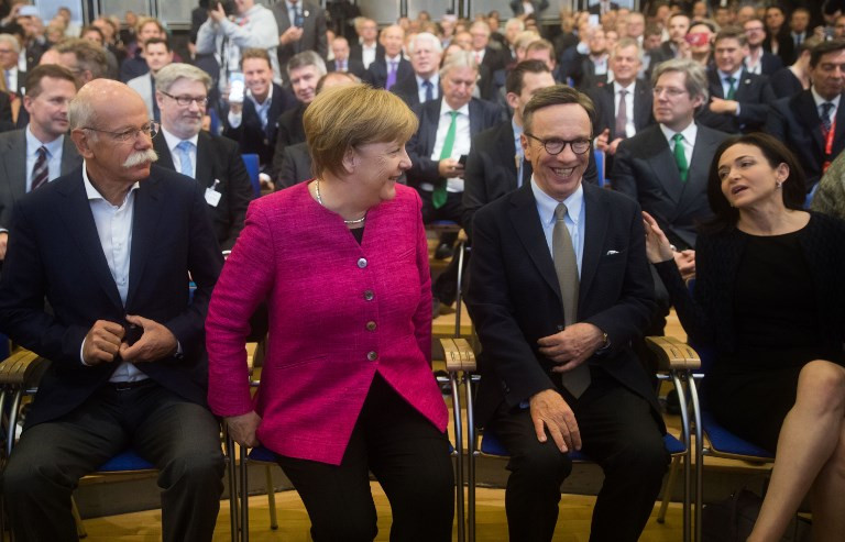 German Chancellor Angela Merkel (2ndL) sits with the CEO of German car maker Daimler AG and head of Mercedes-Benz cars Dieter Zetsche (L), the president of the German Automobile Industry Association (VdA) Matthias Wissmann (2ndR) and Chief Operating Officer (COO) of Facebook Sheryl Sandberg (R) before giving a speech to inaugurate the Frankfurt Motor Show IAA in Frankfurt am Main, western Germany, on September 14, 2017. Chancellor Angela Merkel will formally open the Frankfurt car show on Thursday, where she will face a delicate balancing act between defending millions of duped diesel owners without alienating Germany's most powerful industry.