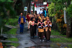Mugiyono (left, dressed in blue) walks with children and other participants to introduce the festival in Kartasura, Central Java, on Saturday (Jan. 12, 2019). JP/Maksum Nur Fauzan