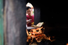 Throw it away: A man burns paper as a symbol of ditching bad luck at the Satya Dharma temple in Benoa, Bali. JP/Anggara Mahendra