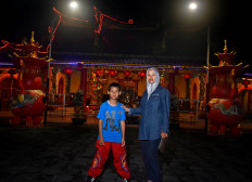 Lusi Hernalisa poses with her 11-year-old son Chalvine before the latter starts training at the temple. JP/Aman Rochman