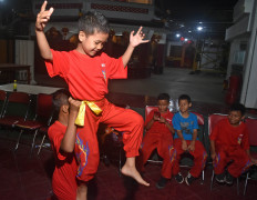 A boy is lifted during a barongsai training session. JP/Aman Rochman