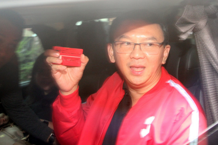 Basuki Tjahaja Purnama shows off his membership card for the Indonesian Democratic Party of Struggle after a visit to the party’s Bali office on Feb. 8, 2019.